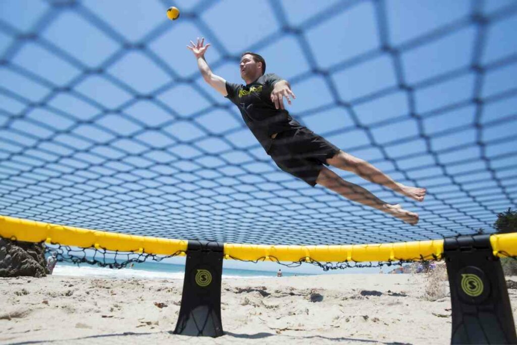 Playing spikeball 1v1 on a beach