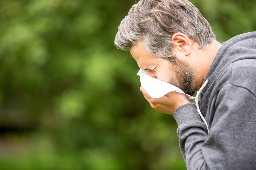 A man sneezing into a tissue.