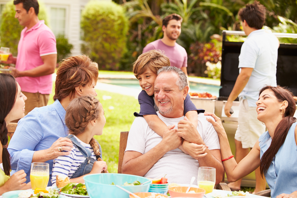 A multigenerational family having a good meal outside.