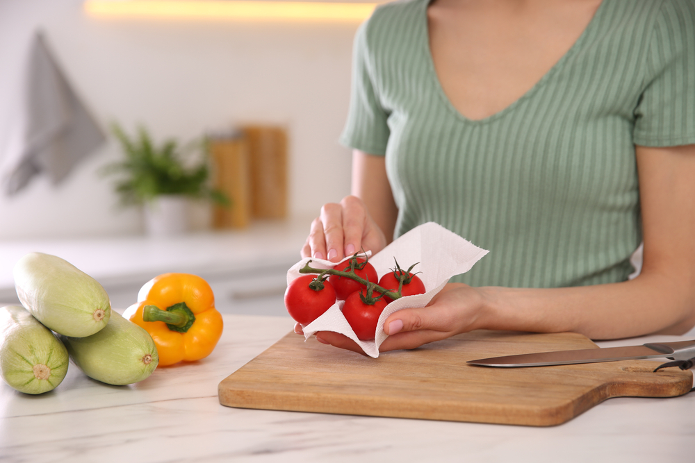 A woman drying off vegetables before cutting them.