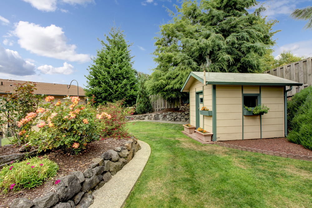 A fenced-in backyard with a garden and shed.